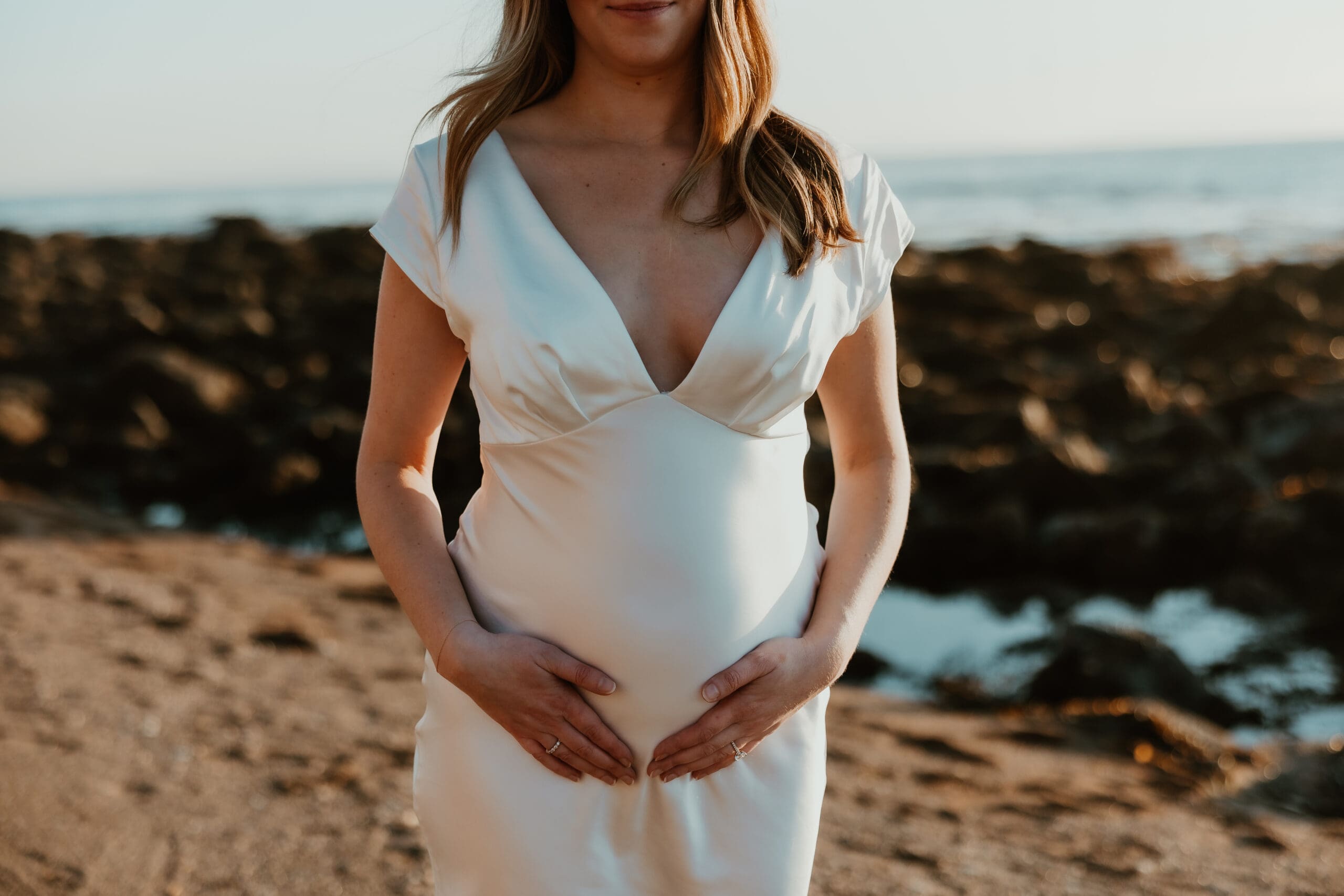 Pregnant woman on Southern California beach during maternity session.